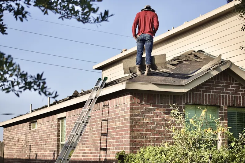 Professional roofer working on a residential roof in Yardley Village